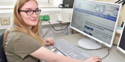 Photo: A trainee with visual impairment at the computer at her workplace; Copyright: !nkA