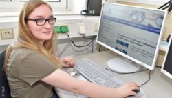 Photo: A trainee with visual impairment at the computer at her workplace; Copyright: !nkA