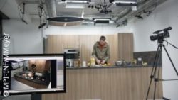 Photo: Marcus Rohrbach cuts fruits in kitchen, camera records scenes, computer screen in foreground