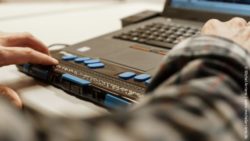 Photo: Hands on a braille display at a laptop; Copyright: Michel Arriens | www.michelarriens.de