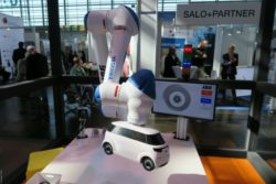 Photo: Robot arm holds a small white car; Copyright: beta-web/Schlüter